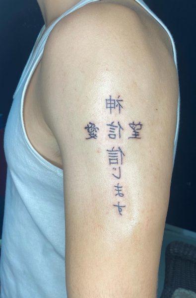 Κινέζικες λέξεις σχηματίζουν ένα σταυρό στο σημείο του μπράτσου